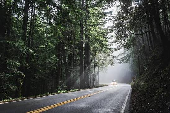 a car is going throught a beautiful road in moutains